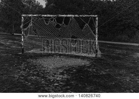 a set of old football goals and net clearly seen better days