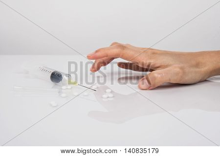 Close-up on the floor of the syringe with the drug. In the background a young drug addict