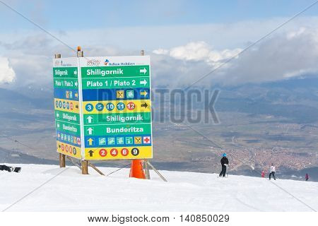 Bansko, Bulgaria - March 4, 2016: Ski resort Bansko, Bulgaria aerial view, skiers, signpost with ski slopes directions