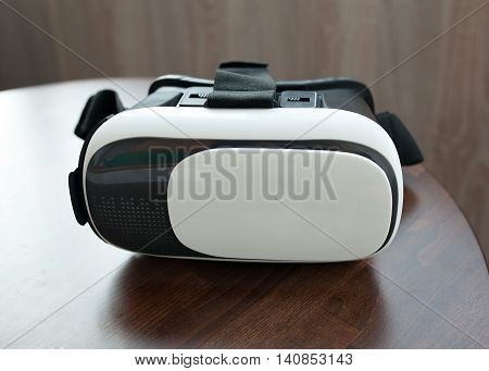 virtual reality glasses on wooden table blurred background.