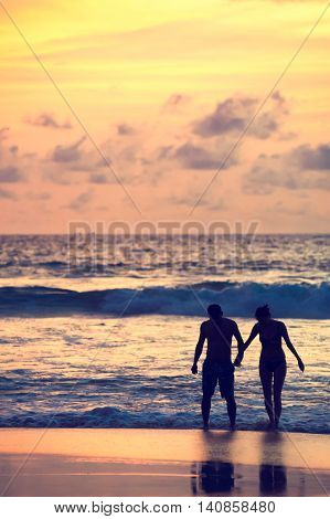 Seascape beautiful sunset beach with silhouette couples together.