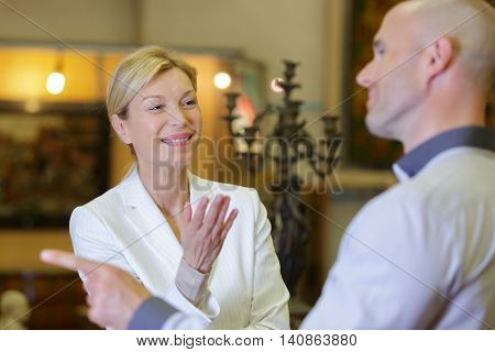 woman auctioneer and man negociating price of item