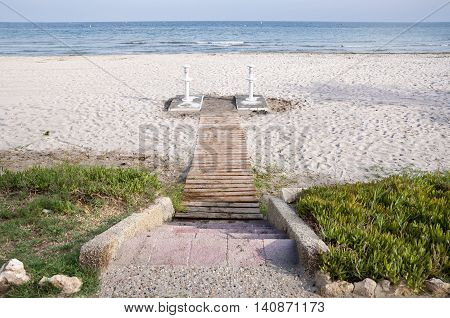Wooden access footpath to the beach. Picture taken in Santa Pola town. It is a coastal town located in the comarca of Baix Vinalopo in the Valencian Community Alicante Spain by the Mediterranean Sea.