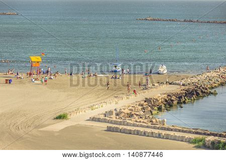 Mamaia Romania - July 18 2016: People resting on beach on in Mamaia Romania. Mamaia is the largest and best known resort on Romanian Riviera. It's situated on 8km long and 300m wide sandy land strip at the Black Sea.