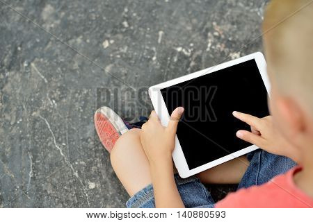 Teenage Boy Using A Digital Tablet In The Street