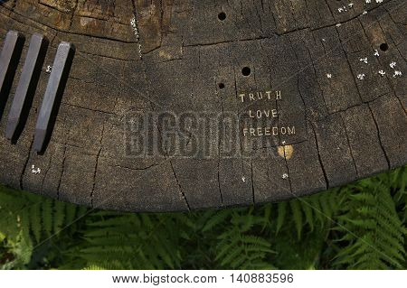Truth, love, freedom words carved into stump and chisels.