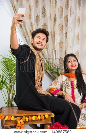 Indian brother taking selfie with sister on Raksha Bandhan festival after tying knot or rakhi