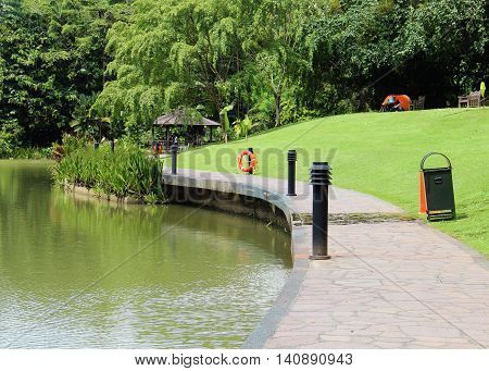 a beautiful park with a lake and a green lawn