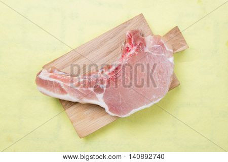 Raw porkchop on wooden broad / cooking porkchop steak concept