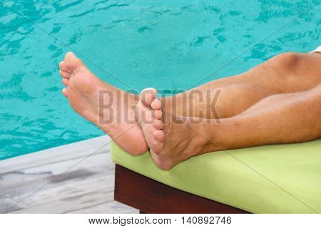 a man sleeping on a  chair by the pool