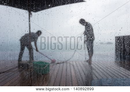 Blurred People Washing Decking By Pressure Wash. Focus On Water Drop