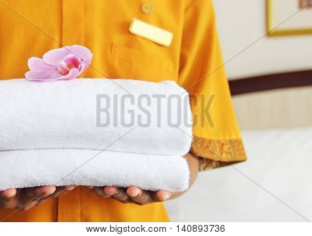 woman in a maid uniform holding towels