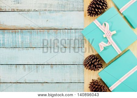Blue gift boxes with pink ribbons and fircones on wood. Valentines day love romance background. Text space