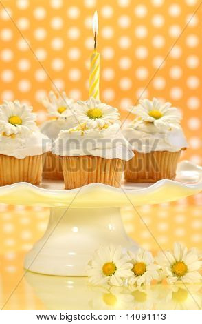 Cupcakes decorados com glacê e pouco margaridas em bandeja de bolo
