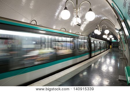 PARIS - JUNE 19 2015: A metro train leaving a Paris Metro station. Paris Metro is the 2nd largest underground system worldwide by number of stations (300).