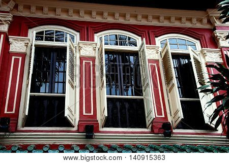 Singapore - December 15, 2007: Finely restored Peranakan home with large windows and louvered wooden shutters in the Emerald Hill Conservation Area
