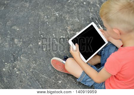 Teenage Boy Using A Digital Tablet In The Street