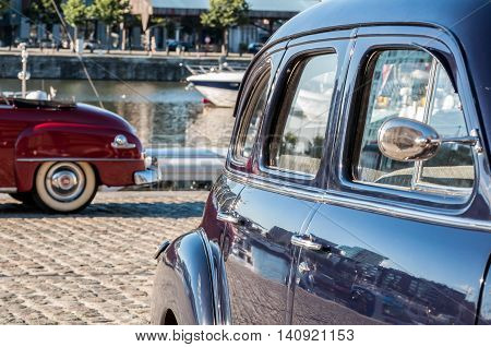 scene of two nice vintage cars near the port
