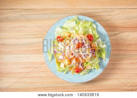 Salad vegetable food vegetarian in a plate placed on a wooden background.