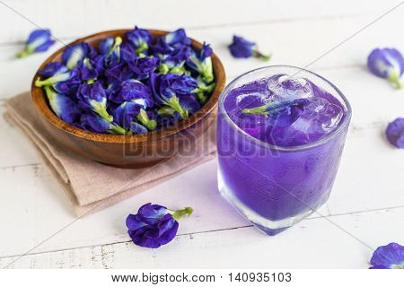 Glass of Butterfly pea or blue pea flower drink on white wooden table