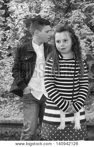 boy with his younger sister posing for the camera