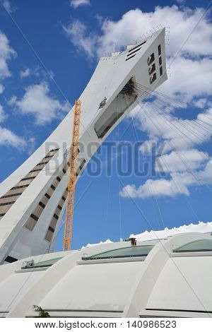 MONTREAL CANADA JULY 30 2016. Men repair the Montreal Olympic Stadium  tower. It's the tallest inclined tower in the world.Tour Olympique stands 175 meters tall and at a 45-degree angle