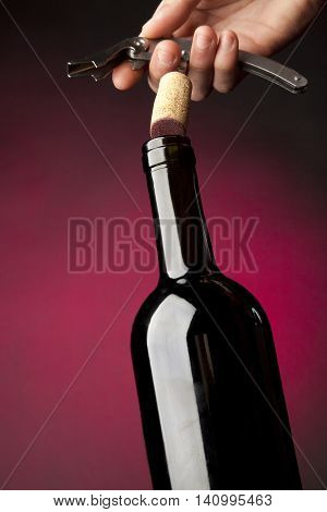 Uncorking a bottle of wine with abstract black background