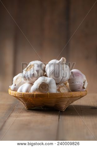 Garlic On Bamboo Basket On Wood Background, Ingredient Food And Herb Concept