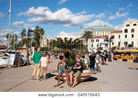 ALGHERO, ITALY -SEPTEMBER 17, 2017: People walking by the port of Alghero, Sardinia, Italy, next to the Centro Storico, the old town of the city