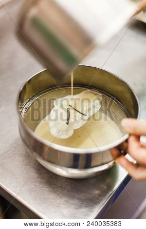 The Process Of Straining When Preparing The Brule Cream. Vanilla Pods On A Steel Sieve. Professional