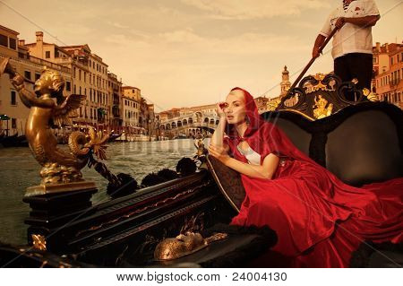 Beautifiul donna in mantello rosso cavalcando gandola