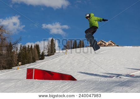 Bolzano, Italy - February 2018: Snowboarder In Action: Jumping In The Mountain Snowpark.