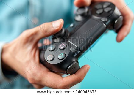 Male hands holding a PS4 controller