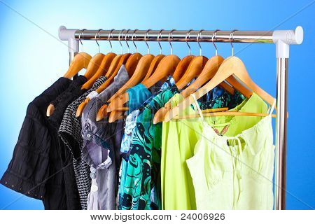 เสื้อผ้าต่าง ๆ บนไม้ hangers บนพื้นหลังสีน้ำเงิน