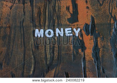 Money Written In White Lettering On Dark Wheathered Wood