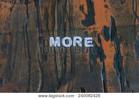 More Written In White Lettering On Weathered Dark Wood
