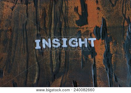 Insight Written In White Lettering On Weathered Dark Wood