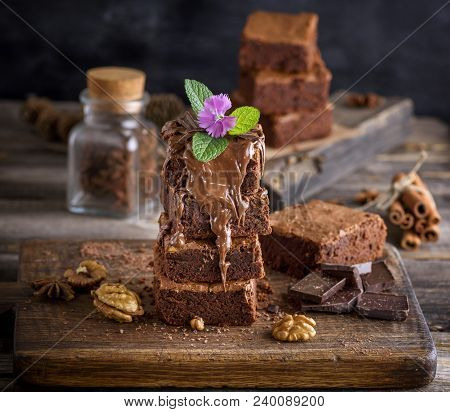 A Stack Of Baked Brownie Pie On A Brown Wooden Board, A Dessert Is Poured With A Thick Layer Of Choc