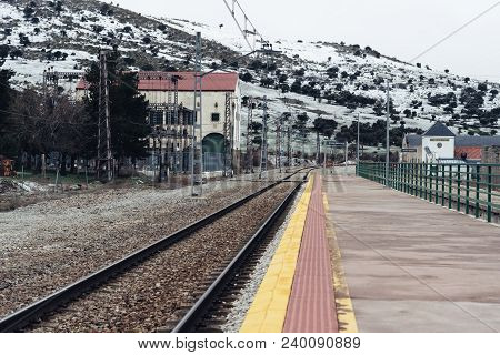 Otero De Herreros, Spain - March 31, 2018: Railway Tracks And Power Station Against Snowcapped Mount