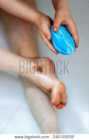 Little Girl Cleaning Her Dirty Feet In The Bathtub