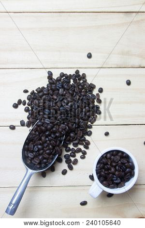 Coffee Beans In Scoop On Wood Background