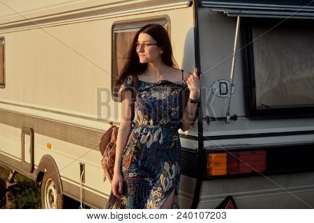 Beautiful Young Caucsian Girl Posing On Front Of A Camper Van On A Sunset. Spirit Of Freedom And You