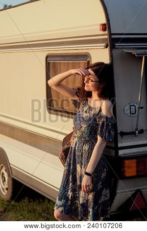 Beautiful Young Caucsian Girl Posing On Front Of A Camper Van On A Sunset. Spirit Of Freedom And You