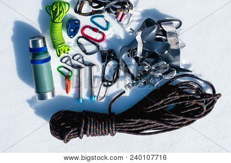 Close-up Of Winter Climbing Equipment On Fresh Snow On A Sunny Day. Carbines With A Rope Gazebo And 