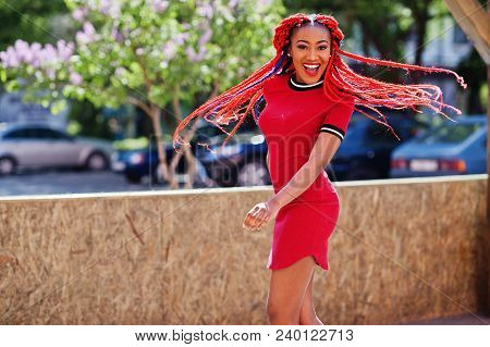 Cute And Slim African American Girl In Red Dress With Dreadlocks In Motion Having Fun On Street. Sty