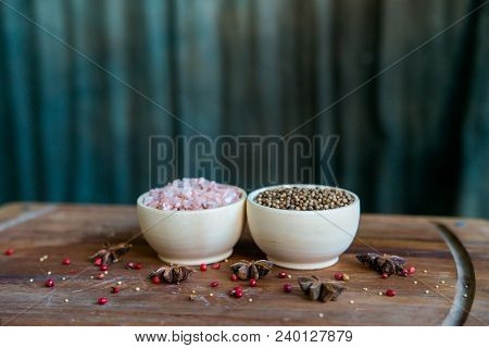 Pink Himalayan Salt And Coriander Seeds In White Bowls On Wooden Surface Covered With Anise And Red 