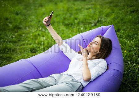 Pretty Young Woman Lying On Inflatable Sofa Lamzac Send Kisses On Video Call Or Take Selfie While Re