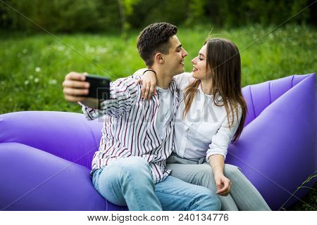 You Are My Soul. Young Couple Hugging And Kissing While Sitting On Inflatable Sofa Lamzac And Take S
