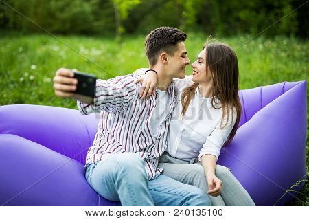 You Are My Soul. Young Couple Hugging And Kissing While Sitting On Inflatable Sofa Lamzac And Take S