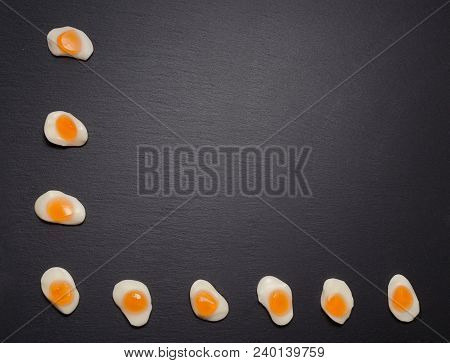 Fried Eggs Candy Sweets Overhead On Dark Background. Jelly Egg Candy On Black Background. Fried Egg 